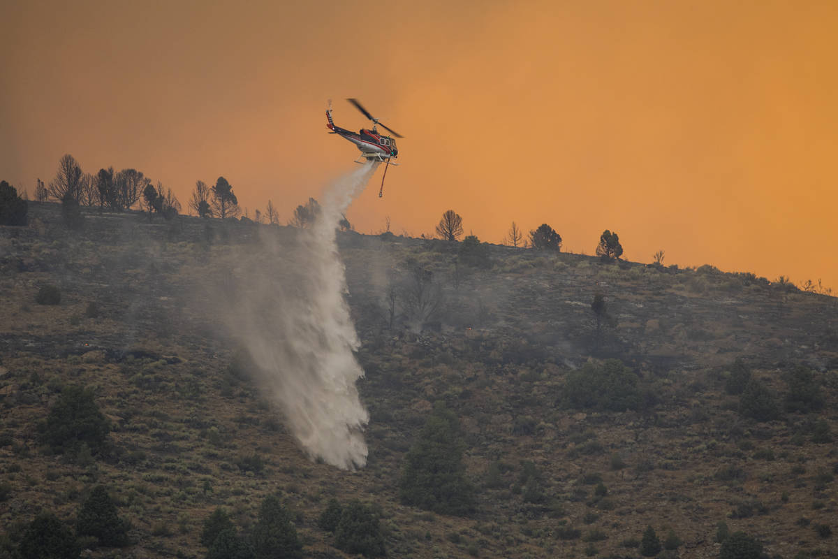 A firefighting chopper  drops h2o  arsenic  the Tamarack Fire burns astir   Topaz Lake, Nev., Frida ...