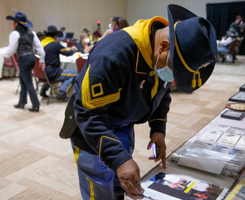 Mitchell Sayles, a member of the Buffalo Soldiers, pages through a scrapbook during an event fo ...