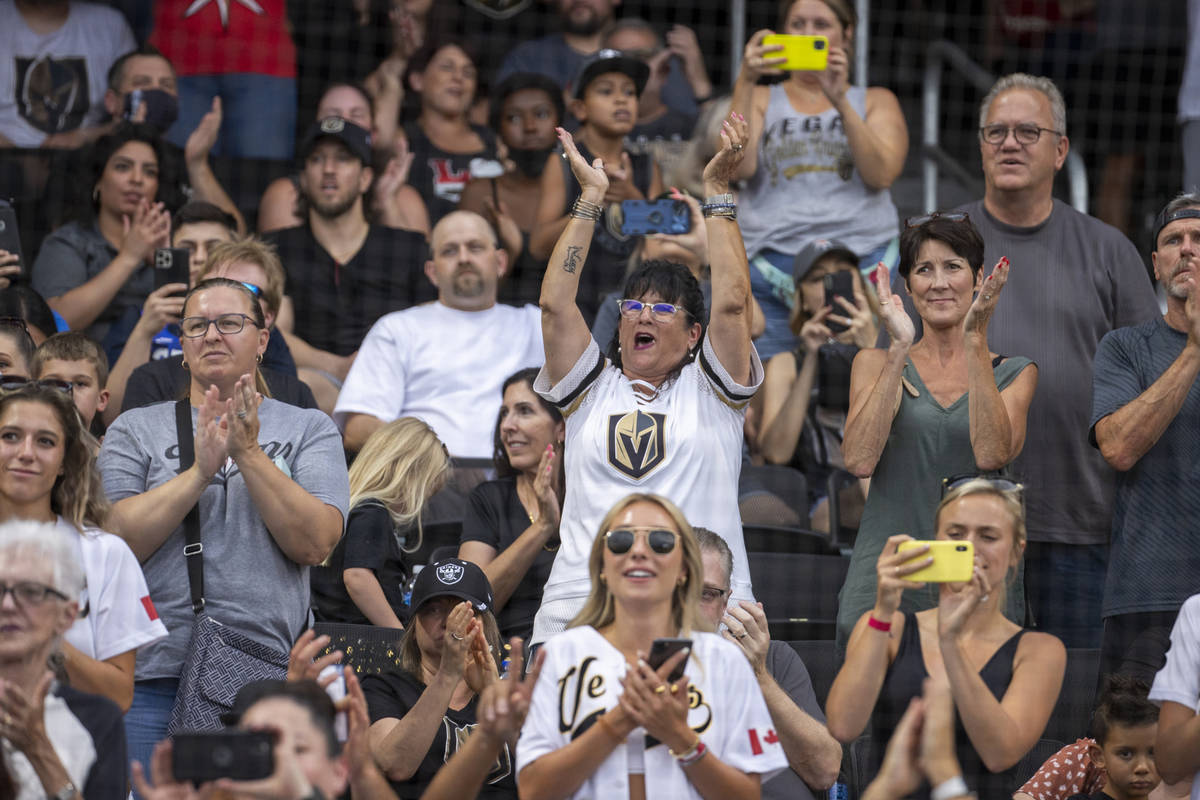 Fans cheers for the players during a charity softball game involving teammates from the Vegas G ...
