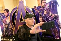 CinemaCon attendee Luis Saint Amant, of Argentina, takes a selfie in front of an advertisement ...