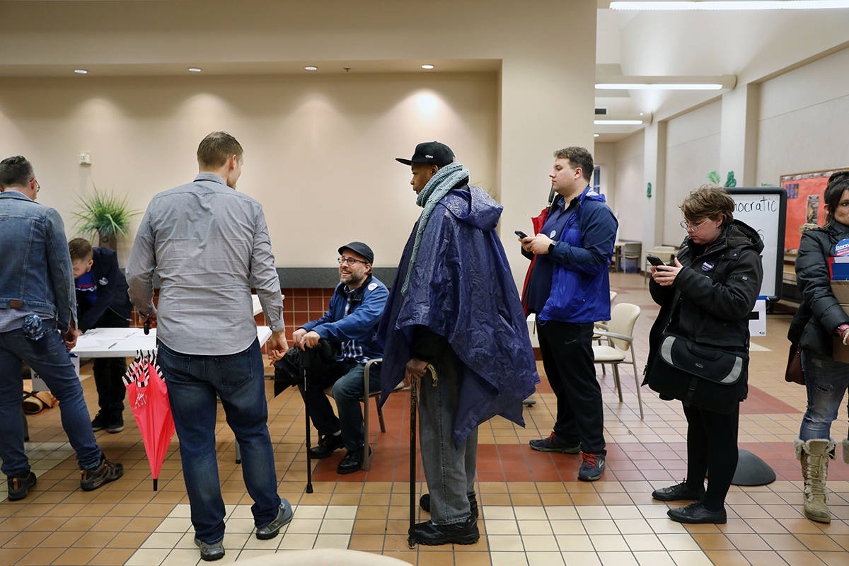 Individuals wait in line to register to caucus at the East Las Vegas Community Center in Las Ve ...