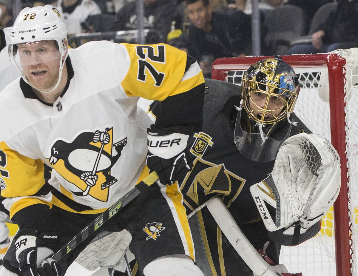 Golden Knights goaltender Marc-Andre Fleury (29) fights for position with Penguins right wing P ...