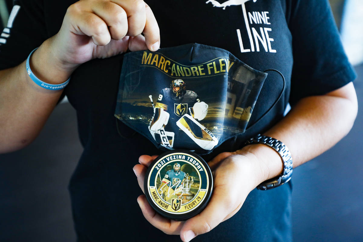 Tonya Fabian holds a puck and mask featuring Golden Knights goaltender Marc-Andre Fleury who wa ...