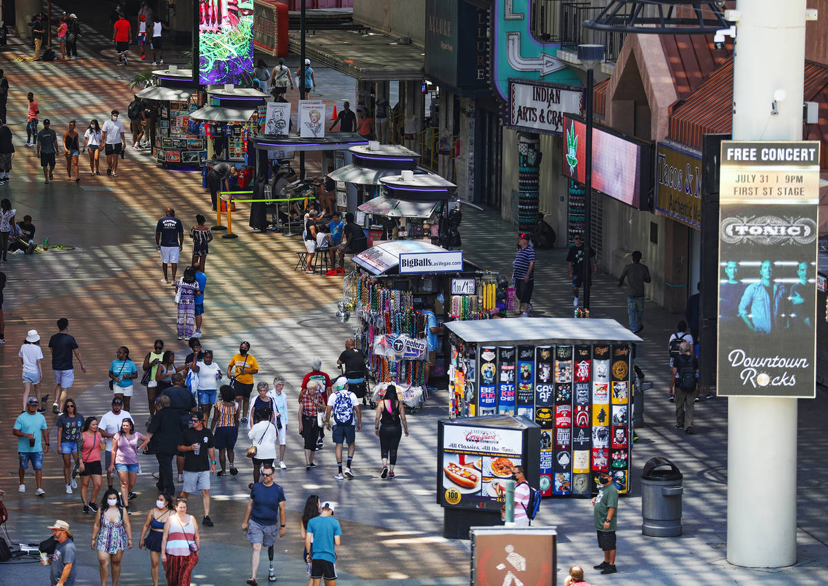 Visitors walk under the Fremont Street Experience in Downtown Las Vegas Wednesday, July 28, 202 ...