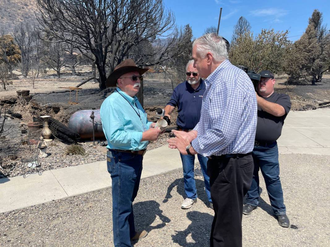 Gov. Steve Sisolak speaking to Douglas County Commissioner Mark Gardner, who helped others evac ...