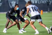 Raiders cornerback Rasul Douglas (38, left) wears a mask while defending against teammate wide ...