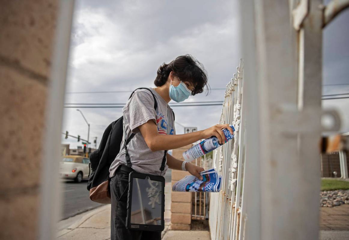 Jacinto Alfaro, a volunteer with the nonprofit Mi Familia Vota, posts COVID-19 vaccine informat ...