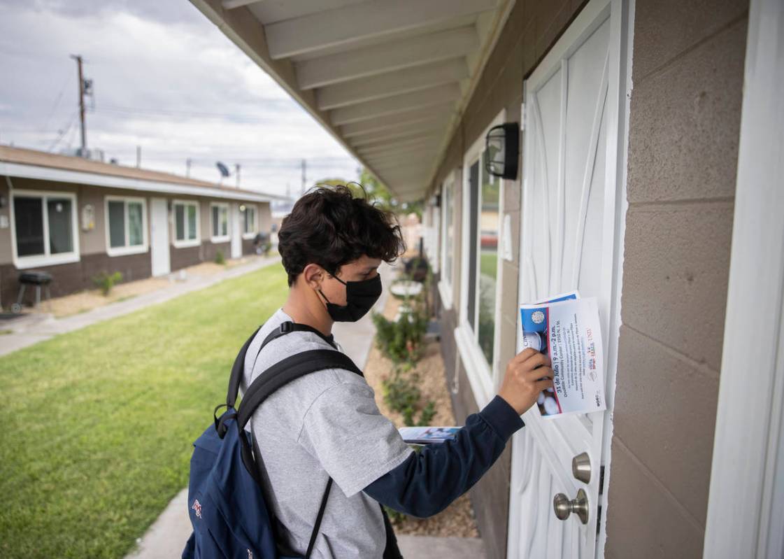 Alan Horta, a volunteer with the nonprofit Mi Familia Vota, posts a COVID-19 vaccine flyer at a ...