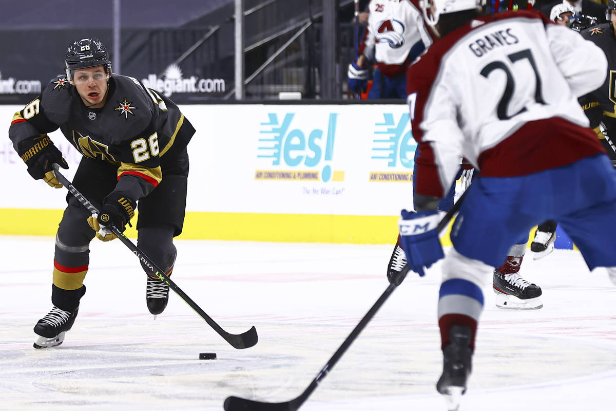 Golden Knights' Mattias Janmark (26) looks to skate past Colorado Avalanche's Ryan Graves (27) ...
