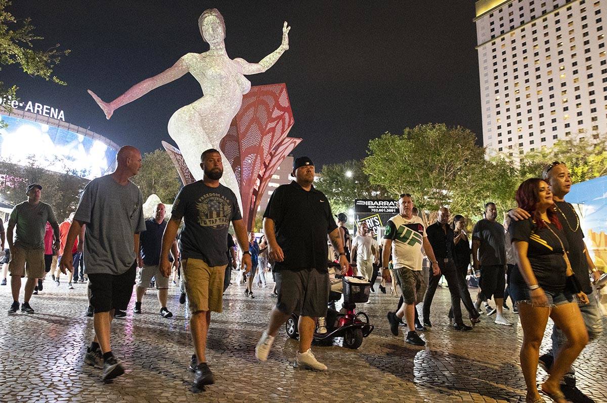 People, nearly all without masks, walk near T-Mobile Arena, on Saturday, July 10, 2021, in Las ...