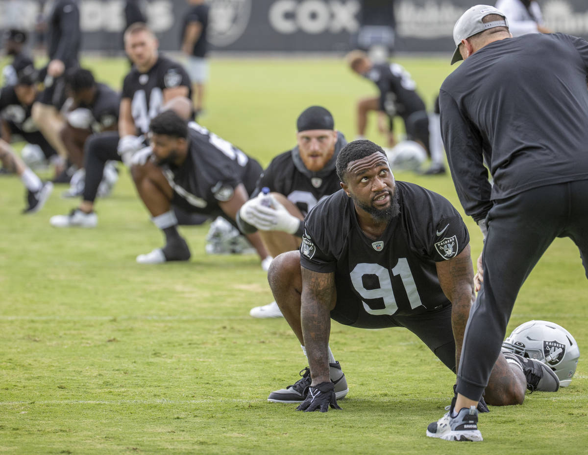 Raiders defensive end Yannick Ngakoue (91) confers with staff during training camp at the Inter ...