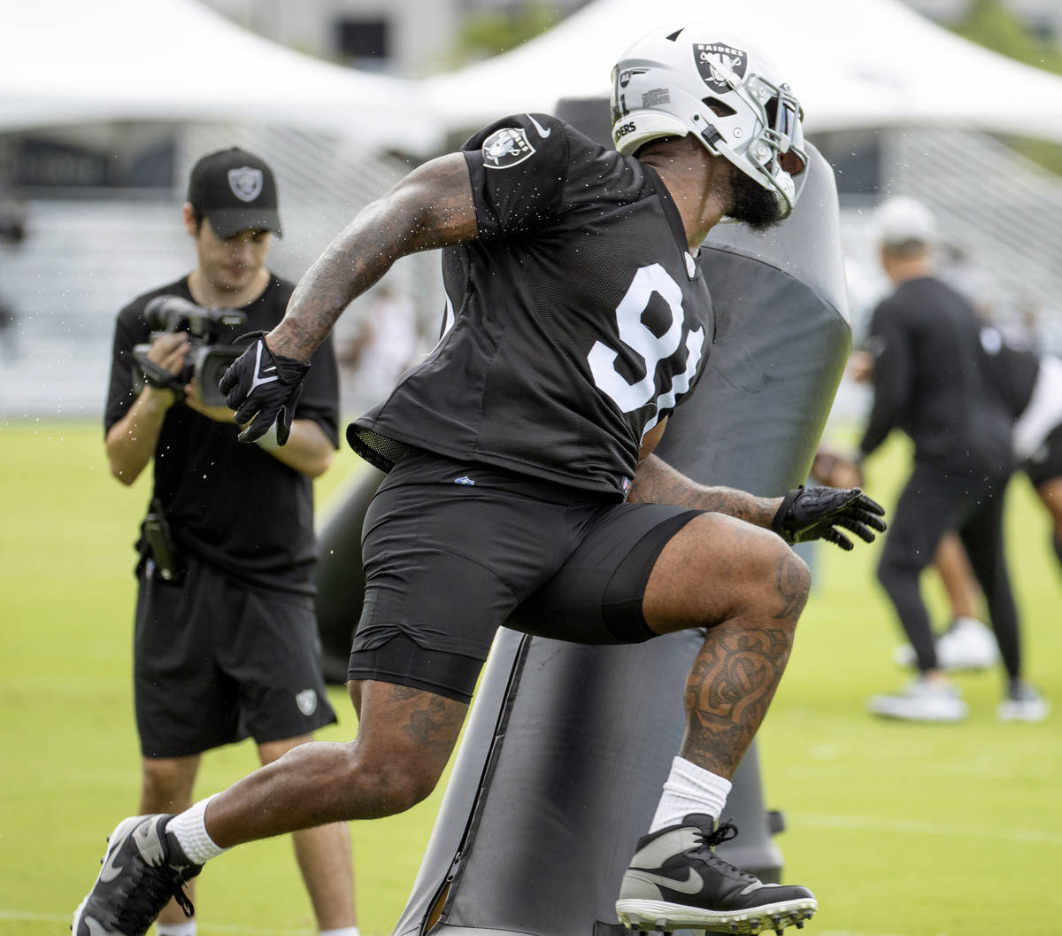 Raiders defensive end Yannick Ngakoue (91) runs around an obstacle during training camp at the ...