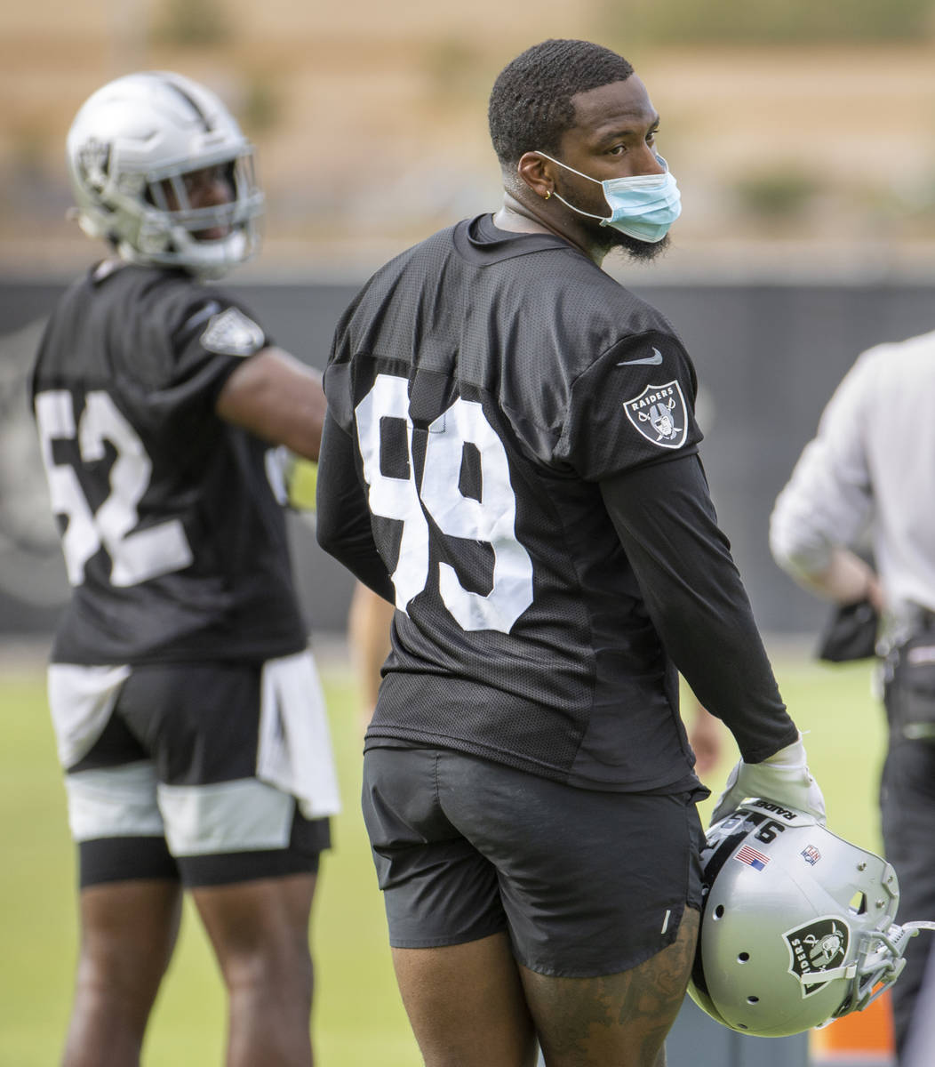 Raiders defensive end Clelin Ferrell (99) is one of a handful of players masking up during trai ...