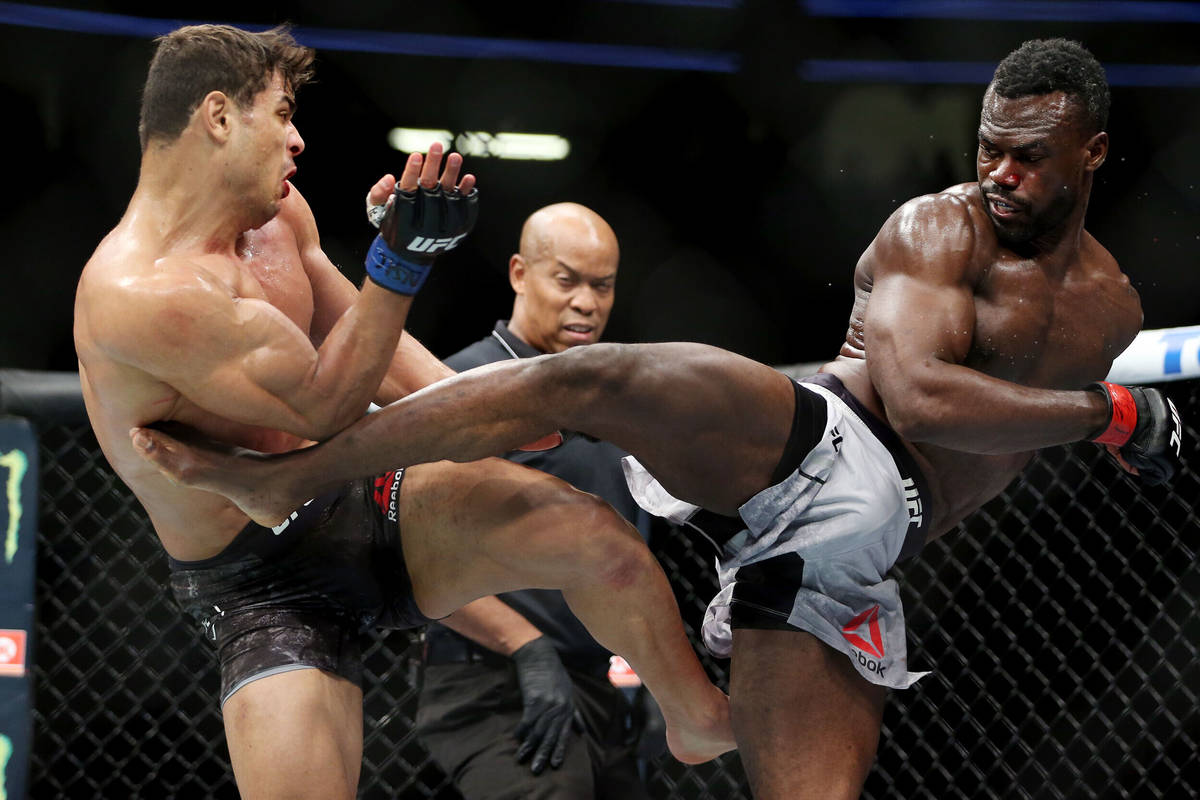 Paulo Costa, left, and Uriah Hall exchange kicks in the middleweight bout during UFC 226 at T-M ...
