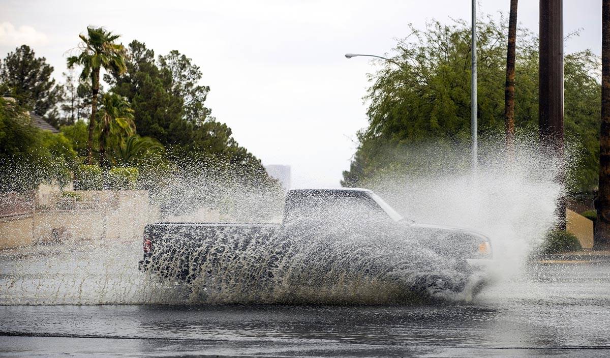 A truck drives through high water on South Buffalo Drive at West Darby Avenue as rain continues ...