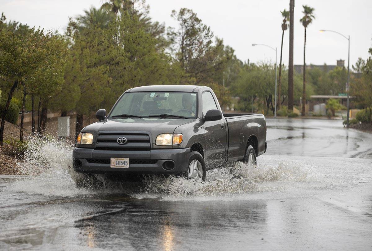 A truck navigates through high water about West Darby Avenue and South Blue Monaco Street as ra ...