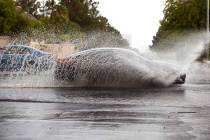 A car drives through high water on South Buffalo Drive at West Darby Avenue as rain continues a ...