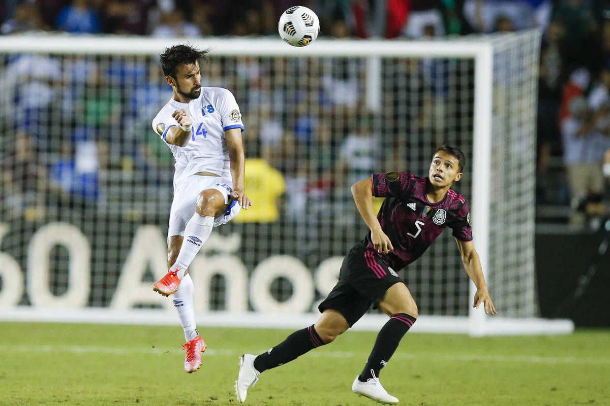 El Salvador forward Joaquin Rivas (14) and Mexico defender Osvaldo Rodriguez (5) vie for the ba ...
