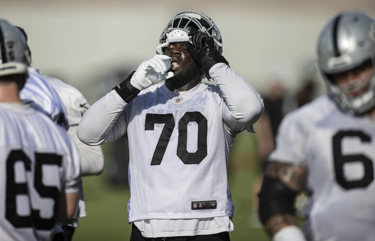 Raiders offensive tackle Alex Leatherwood (70) drinks water during training camp on Saturday, J ...
