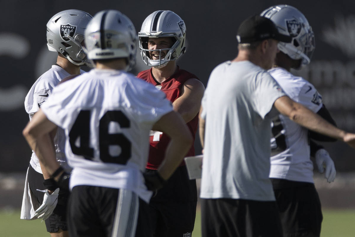 Raiders quarterback Derek Carr (4), red, directs the offense during training camp on Saturday, ...