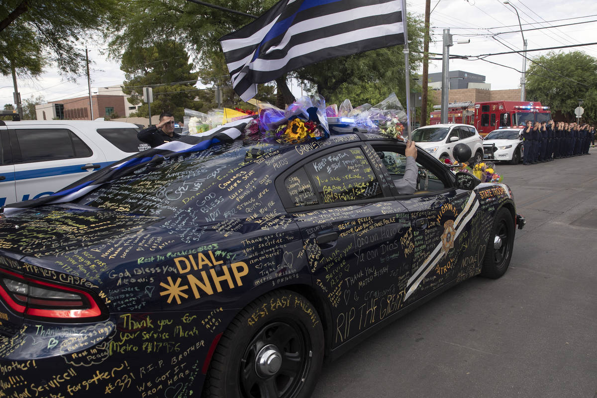 Nevada Highway Patrol trooper Micah May's squad car is decorated with signatures, flowers and f ...