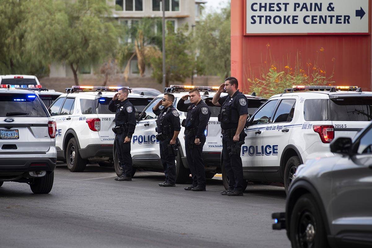 North Las Vegas police officers salute to a procession moving the body of slain Nevada Highway ...