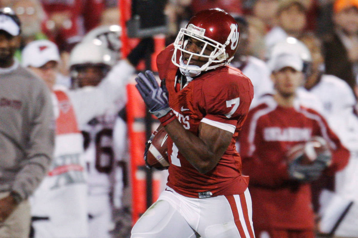 Oklahoma's DeMarco Murray runs past the Texas A&M bench in the second quarter of an NCAA co ...