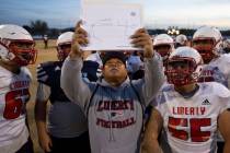 Liberty High School coach Al Tucay holds up a play for the team during football practice at Lib ...