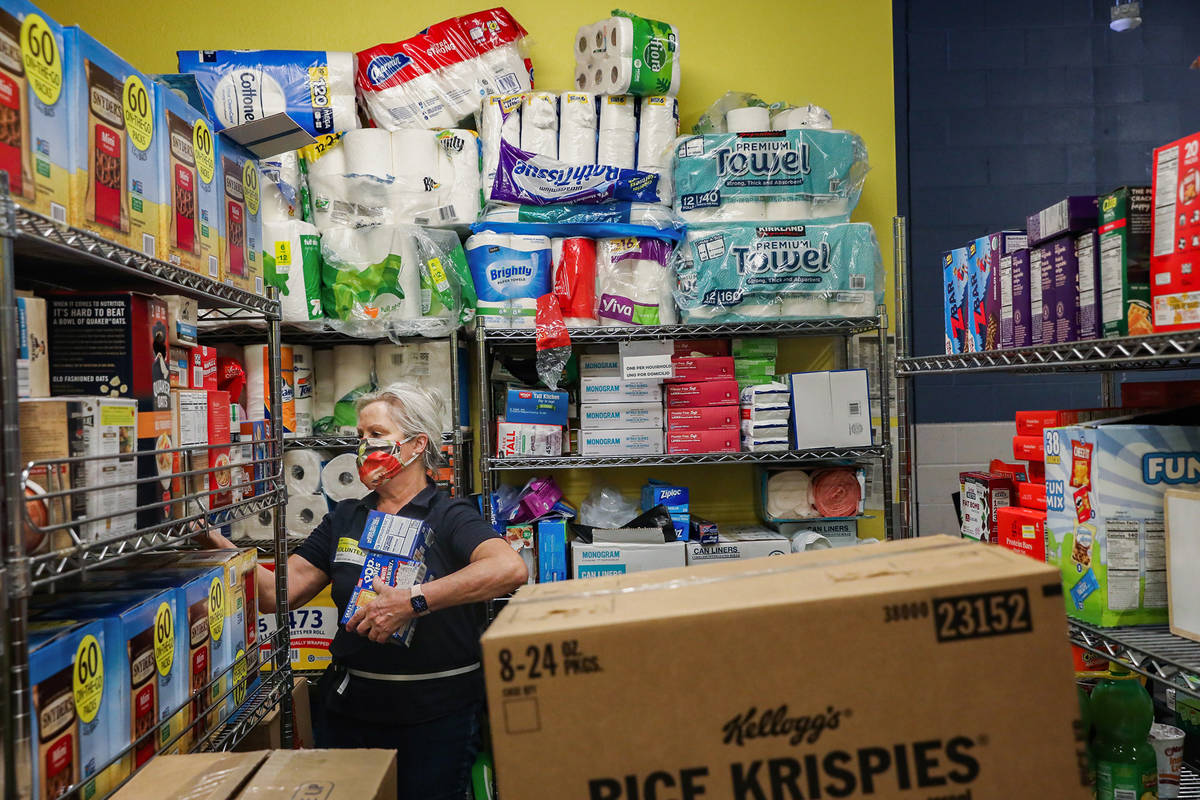 Volunteer Alicia Brasuell unloads items onto shelves in the storage room in the food pantry at ...