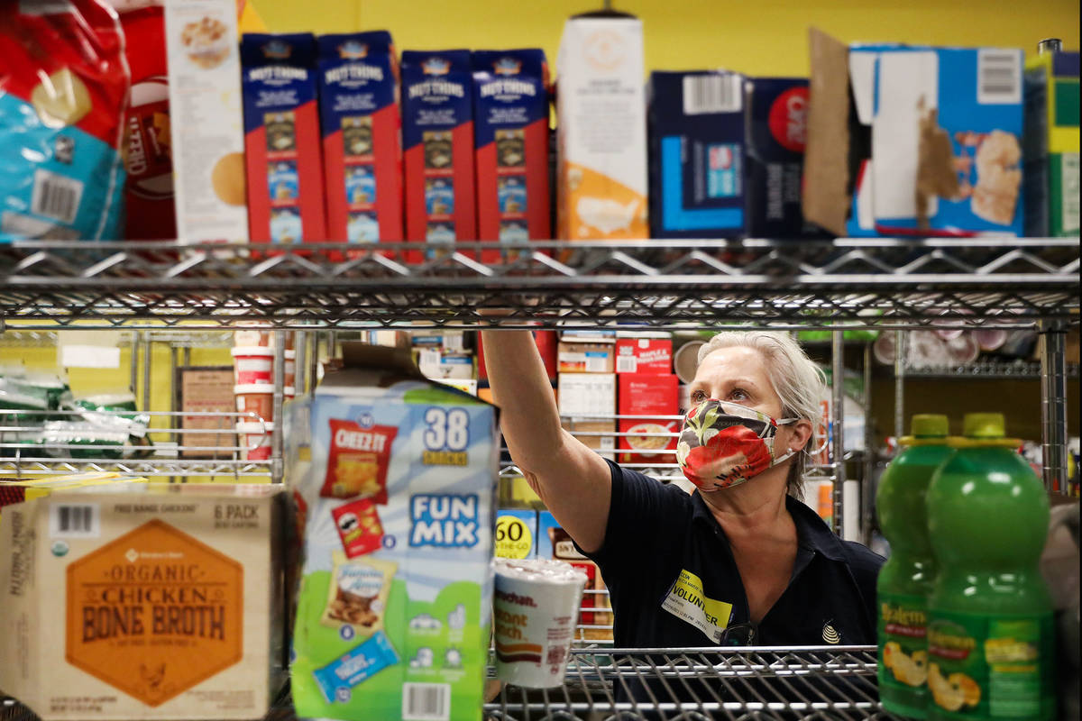 Volunteer Alicia Brasuell unloads items onto shelves in the storage room in the food pantry at ...