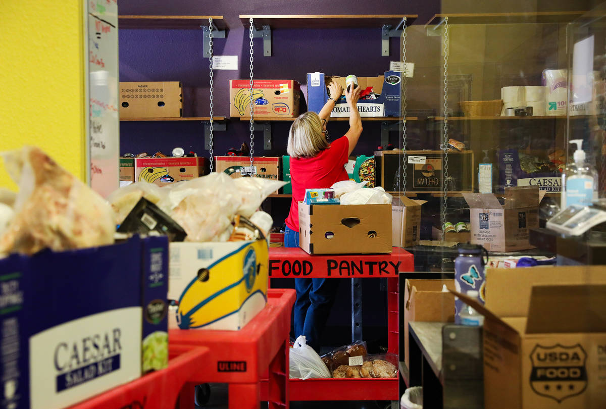 Volunteer Linda O'Connell packs boxes of food for people to pick up in the food pantry at Catho ...