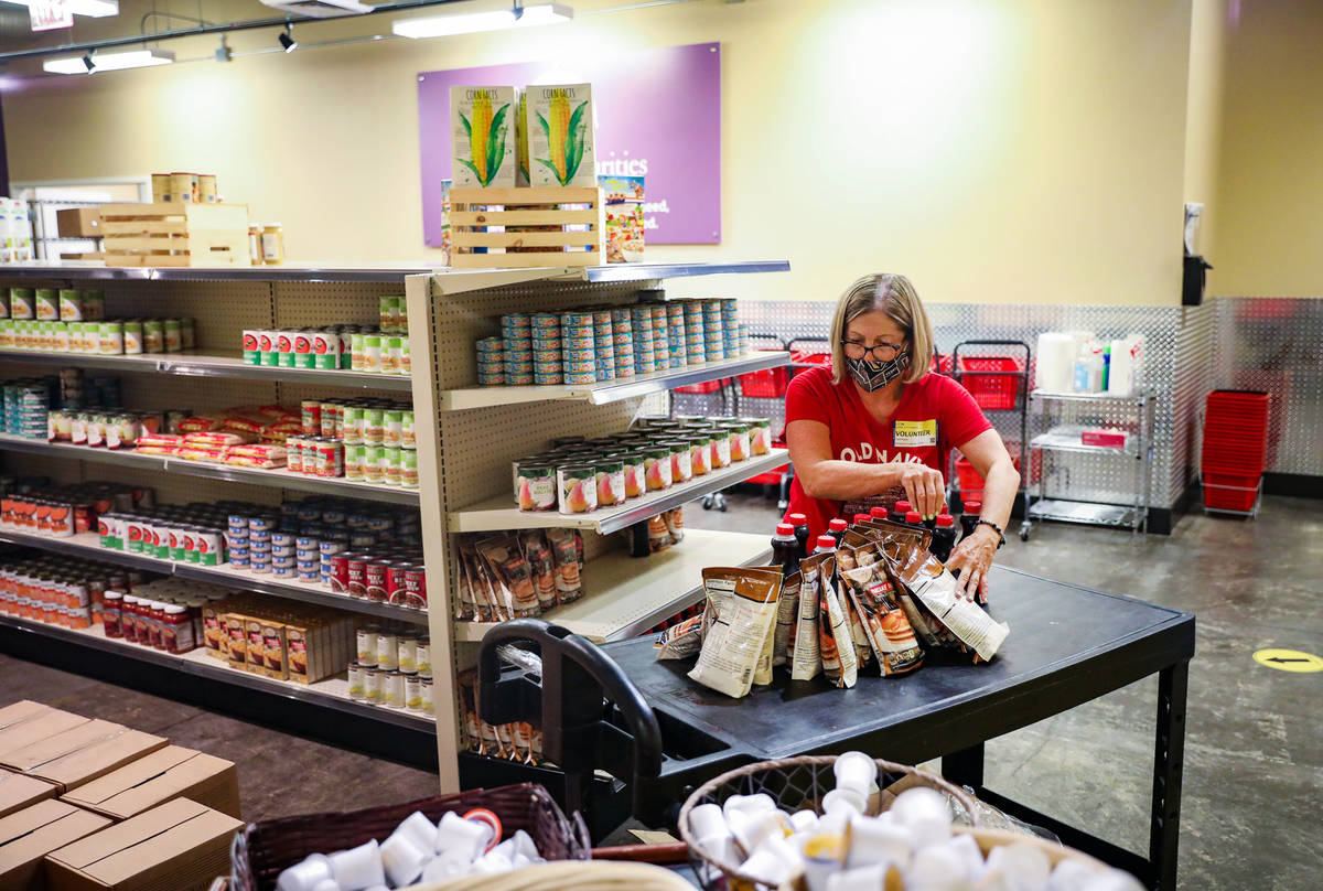 Volunteer Linda O'Connell stocks up a cart of items in the food pantry at Catholic Charities of ...