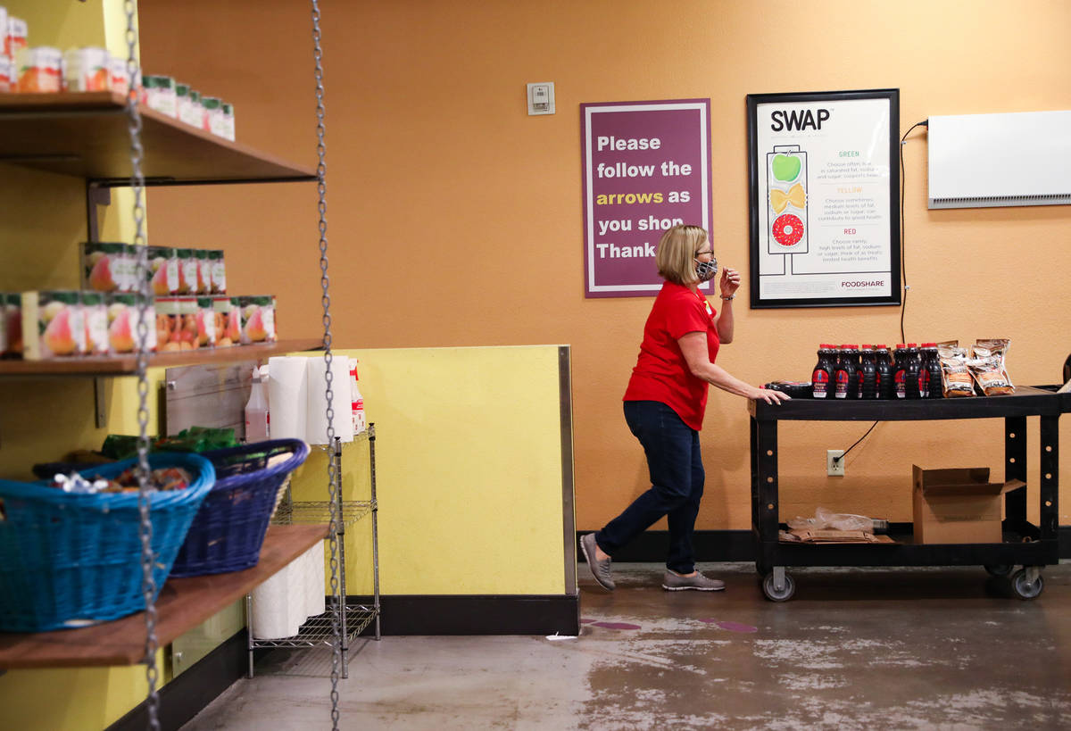Volunteer Linda O'Connell pushes a cart of items in through the food pantry at Catholic Chariti ...