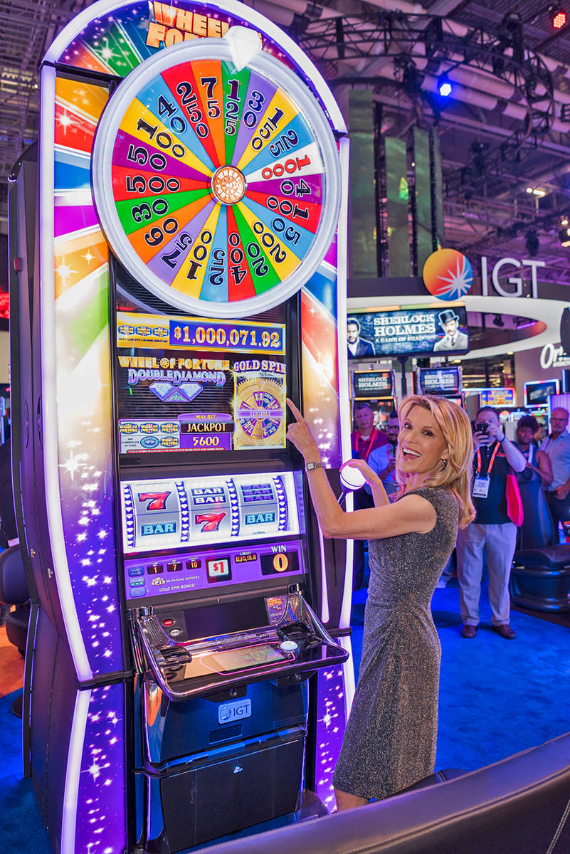 Wheel of Fortune co-host and letter-turner Vanna White plays a Wheel of Fortune slot machine at ...