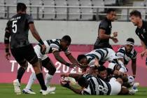 Fiji's Waisea Nacuqu passes off the ground to Aminiasi Tuimaba in their men's rugby sevens gold ...