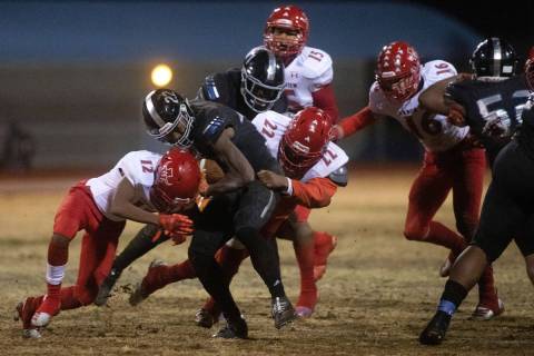 Desert Pines' running back Jovantae Barnes (22) pushes through a tackle from Arbor View's quart ...