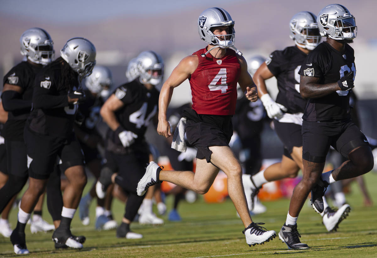 Raiders quarterback Derek Carr (4) warms up with teammates during training camp on Monday, Aug. ...
