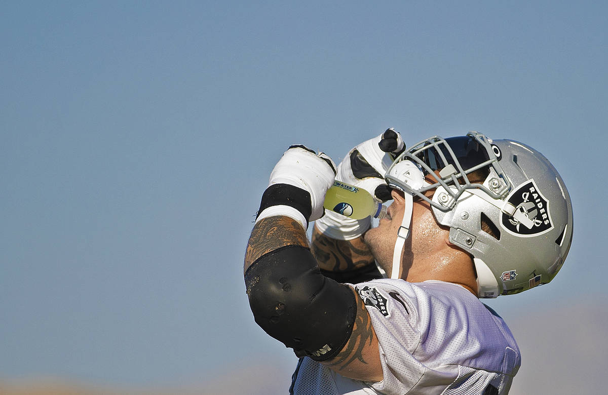 Raiders offensive guard Richie Incognito (64) hydrates during a break at training camp on Monda ...