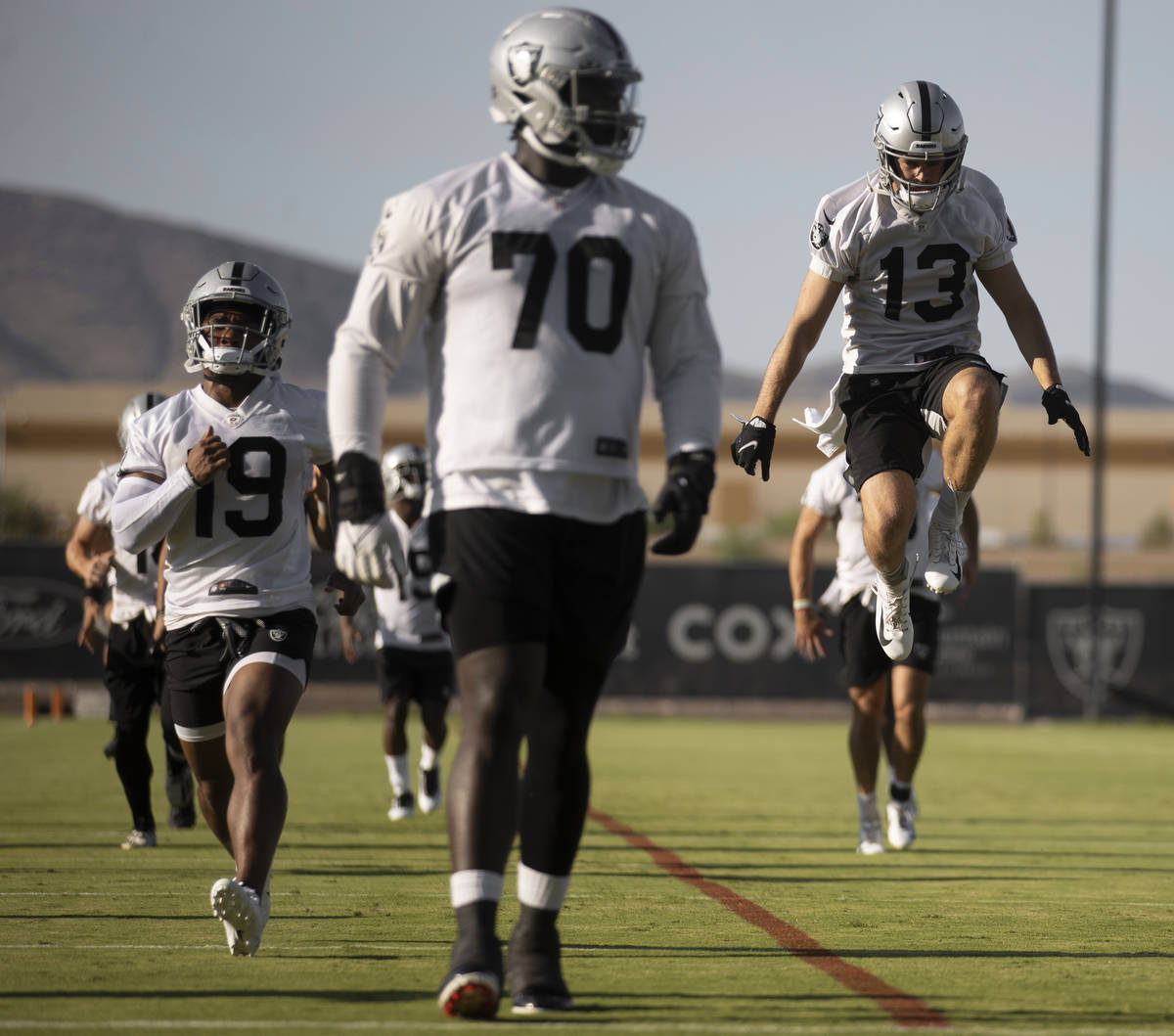 Raiders wide receiver Hunter Renfrow (13) leaps in the air while stretching at training camp on ...
