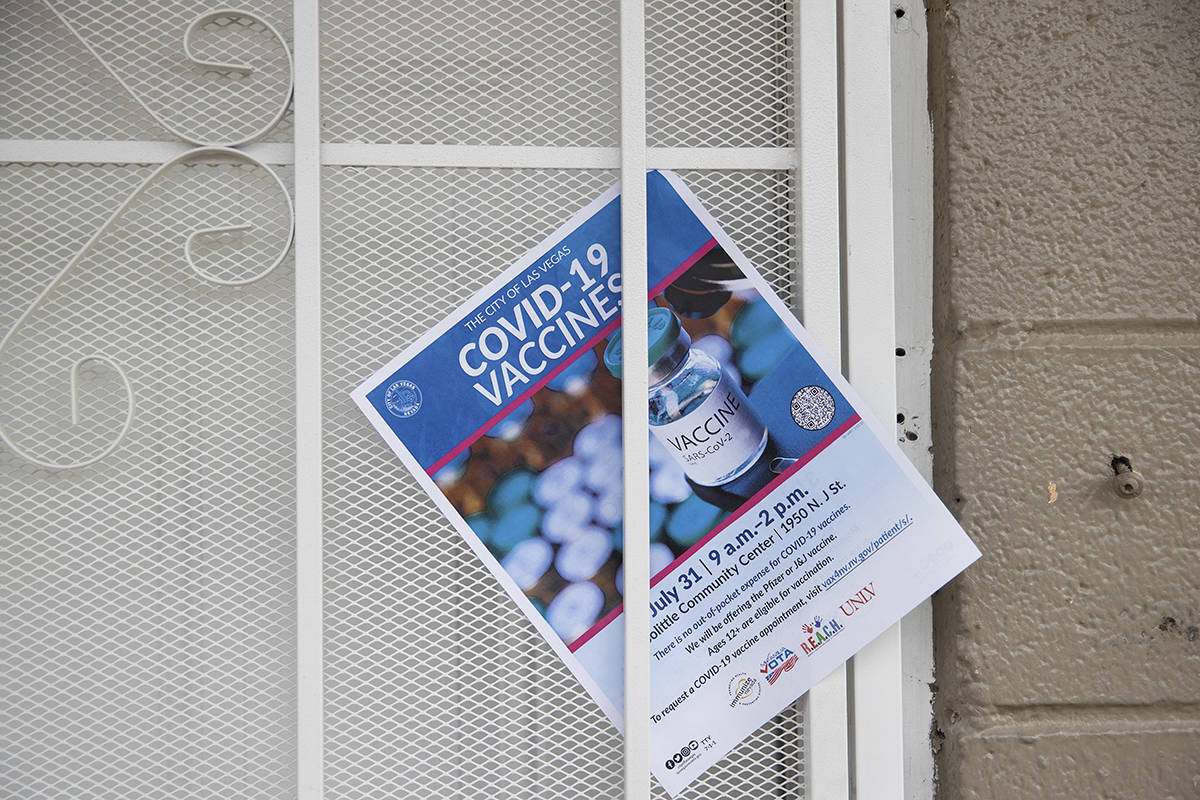 A COVID-19 vaccine information flyer placed on the door at an apartment complex by nonprofit vo ...
