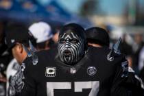 Raiders super fan Wayne Mabry, known as "Violator," walks through a tailgate outside ...