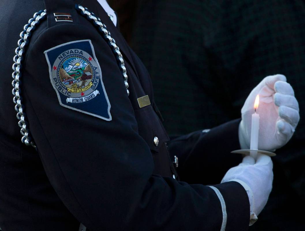 A member of the Honor Guard shields his candle during a vigil for Nevada Highway Patrol trooper ...