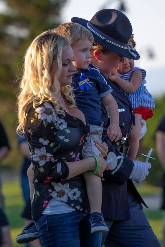 Joanna May holds her son Raylan May while a member of the Honor Guard brings her daughter Melod ...