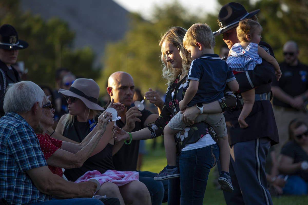 Joanna May, holding her son Raylan May, helps family members to light candles during a vigil fo ...