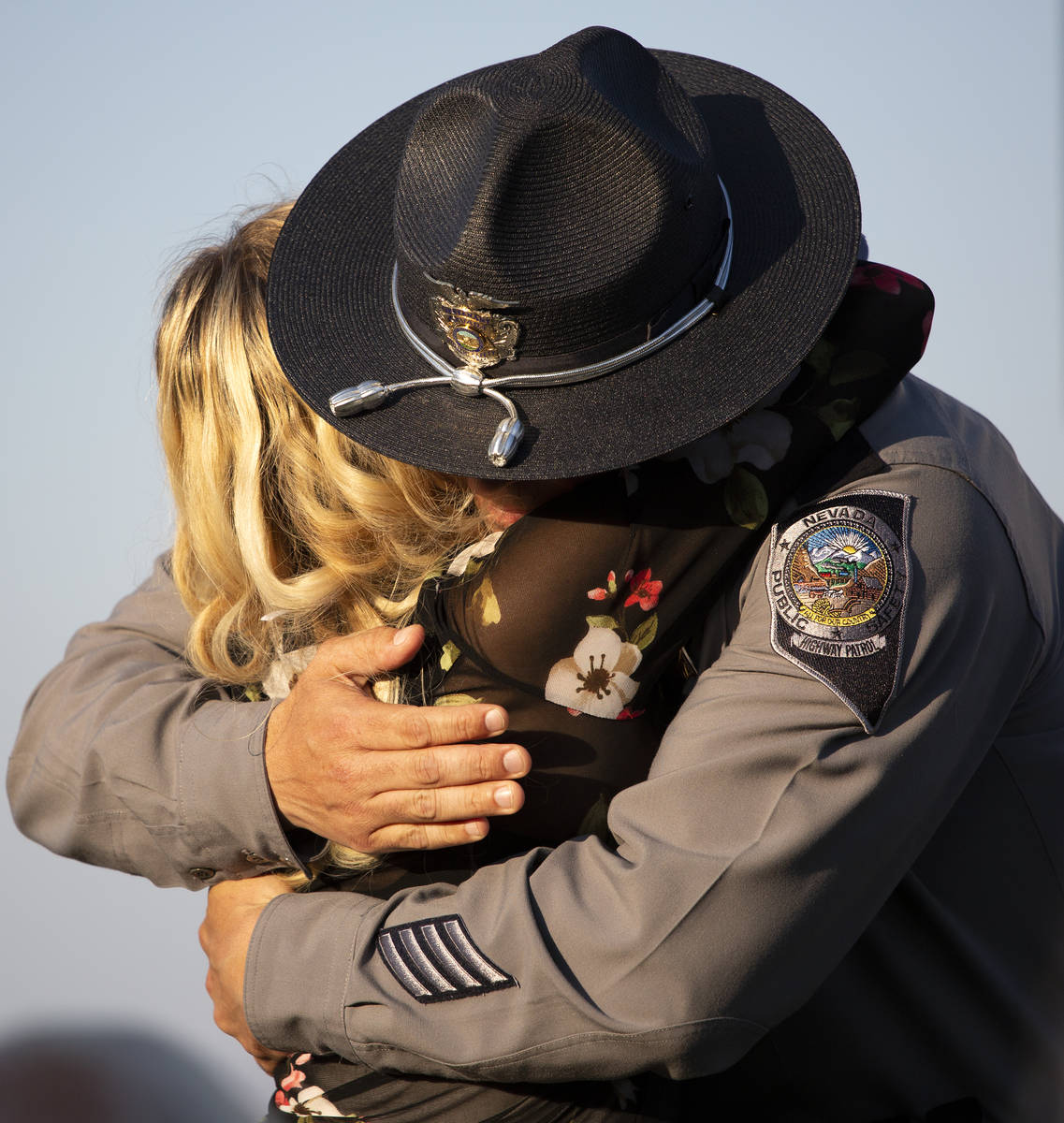 Joanna May hugs Nevada Highway Patrol Lt. Anthony Munoz after he spoke during a vigil for her h ...