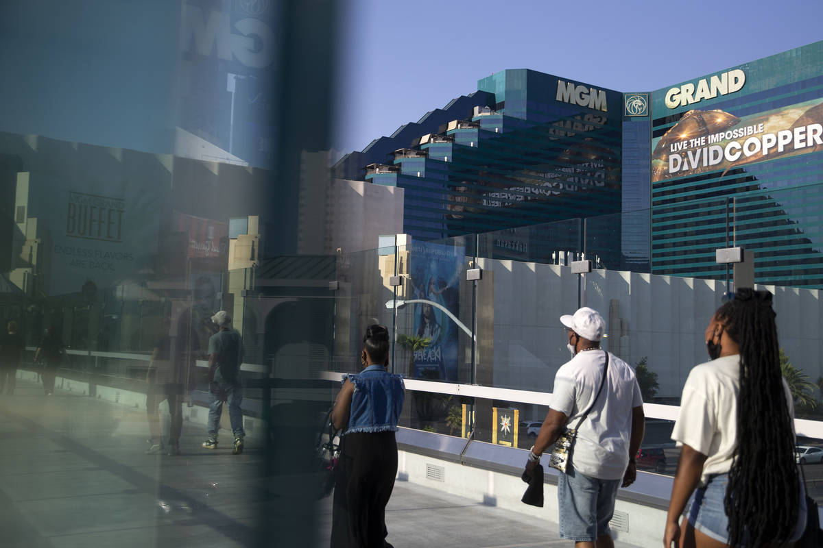 Travelers cross a pedestrian bridge past MGM Grand on Wednesday, Aug. 4, 2021, on the Las Vegas ...