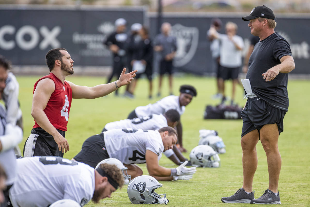 Raiders quarterback Derek Carr (4) talks while on his knees with Head Coach Jon Gruden during t ...