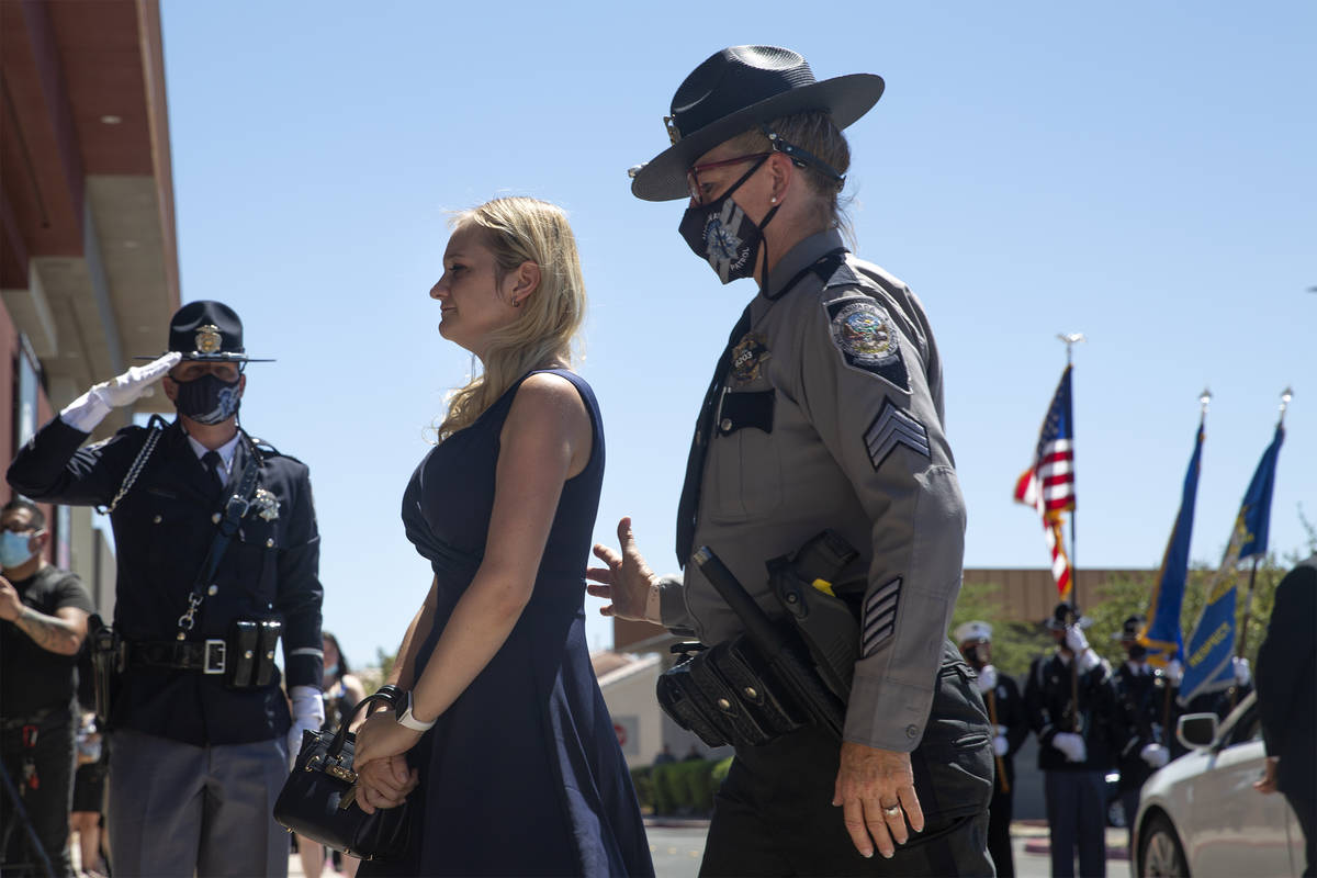 Joanna May, wife of Nevada Highway Patrol trooper Micah May, is guided into her husband's memor ...