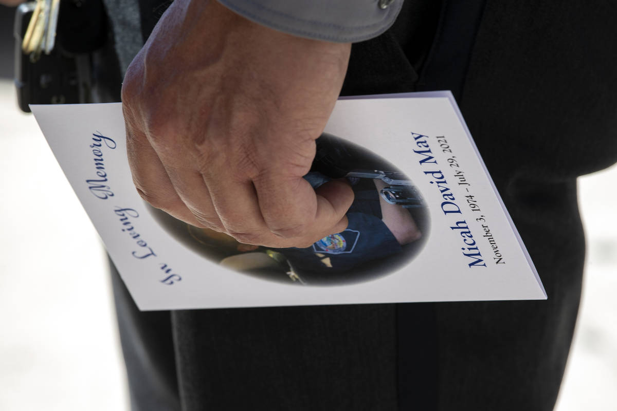 One attendee of Nevada Highway Patrol trooper Micah May's memorial service carries a program in ...
