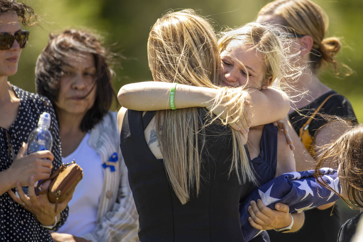 Joanna May, wife of slain Nevada Highway Patrol trooper Micah May, receives a hug while holding ...